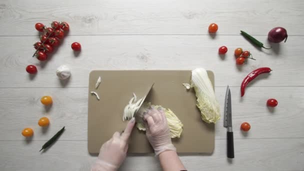 Chef coupe le chou chinois sur une planche de plastique vue du dessus
 - Séquence, vidéo