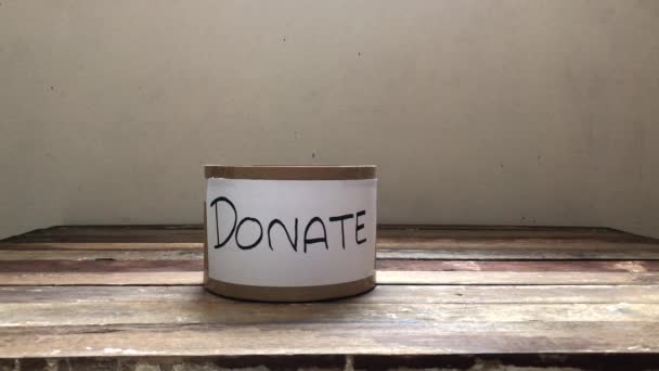 Spende für verhindertes Virus covid-19 Concept.Donate Box hat hygienische medizinische Masken auf Holztischplatte, zur Unterstützung der Unterprivilegierten oder des medizinischen Personals, schwach beleuchtet, selektiver Fokus. - Filmmaterial, Video