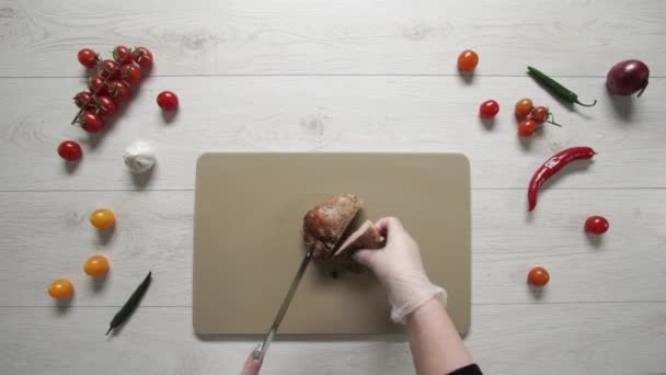Šéf krájí pečené vepřové maso na plastové desce horní pohled - Záběry, video