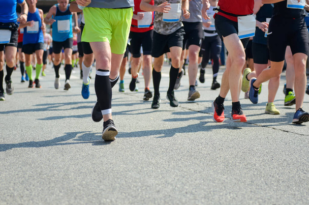 Carrera de maratón, muchos corredores pies en las carreras de carretera, la competencia deportiva, fitness y el concepto de estilo de vida saludable - Foto, imagen
