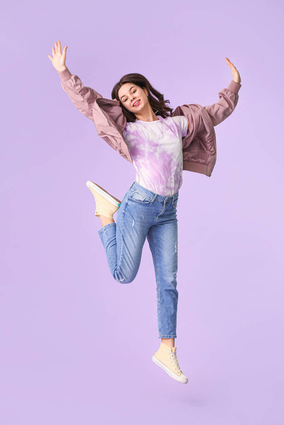 Beautiful young woman jumping on color background - Foto, imagen