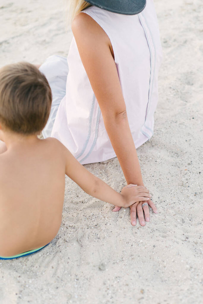 little boy holds the hand of his mother. Beach holiday - Φωτογραφία, εικόνα
