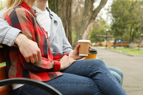 Couple sitting in the park and drink coffee - Photo, Image