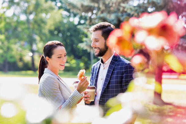 Portrait of young attractive business couple dating in park during break - Фото, зображення