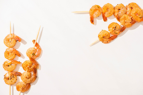 top view of delicious fried prawns on skewers on white background - Zdjęcie, obraz