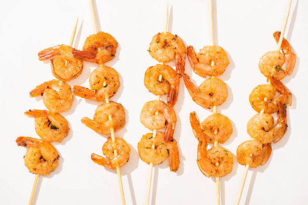 top view of delicious fried prawns on skewers on white background - Fotografie, Obrázek