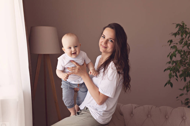 Casual lifestyle photo of young mom with her one year old son at home - Фото, изображение