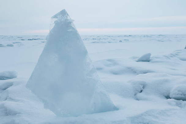 Los témpanos azules transparentes apilados en hummoquks del hielo contra un cielo azul en un día soleado. Inusual paisaje invernal del lago congelado Baikal. Fondo frío natural. Siberia, Rusia. - Foto, imagen