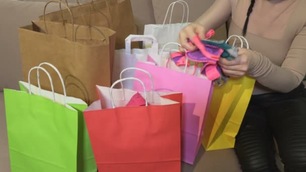 Nő otthon vásárlás után kukucskál a bevásárló táskák felülvizsgálata a vásárlások - Felvétel, videó