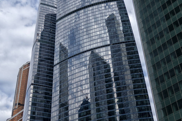 Kilátás a felhőkarcolókra alulról. Felhőkarcolók a kék ég ellen. Magas épület. A város üzleti központja. Modern városi építészet. Üvegből és betonból készült házak. - Fotó, kép