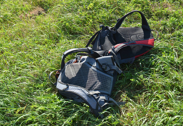 Tijd om te pauzeren en uit te rusten. Twee ingepakte rugzakken op het gras wachten op de toeristen om te gaan wandelen. - Foto, afbeelding