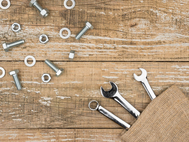 Wrenches, bolts and nuts on wooden background. - Foto, afbeelding