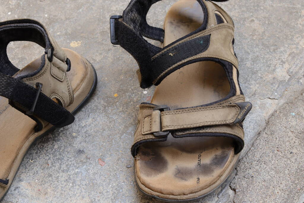 Męskie stopy w brązowych skórzanych sandałach - Zdjęcie, obraz