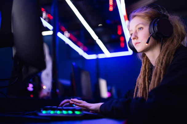 Streamer hermosa chica profesional gamer sonrisa jugando juegos en línea ordenador con auriculares, color neón - Foto, imagen