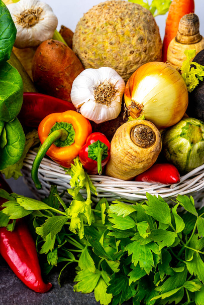 Widok z bliska wiklinowy kosz pełen świeżych warzyw i korzeni - Zdjęcie, obraz