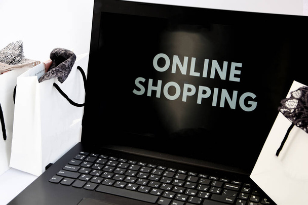 Çevrimiçi Alışveriş Siparişi Dükkanına Ekle Satış Online alışveriş konsepti, alışveriş torbaları ve beyaz izole bir arka planda açık bir laptop - Fotoğraf, Görsel