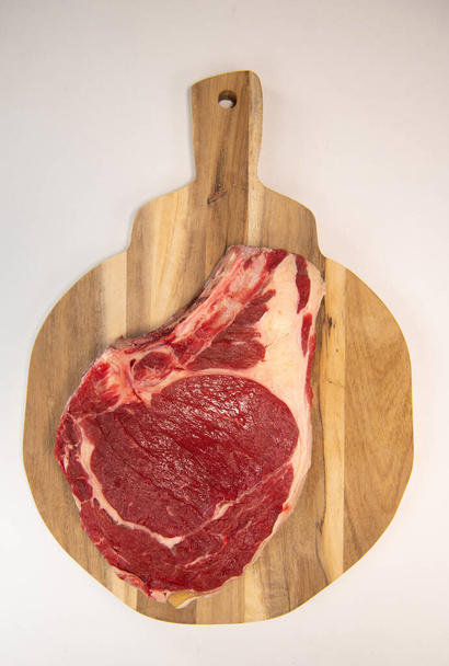 Raw T Bone steak on wooden board prepared to Grill  - Foto, afbeelding