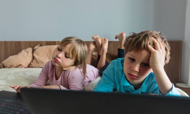 bambini annoiati con il computer a casa, ragazzo e ragazza stressati ed esausti - Foto, immagini