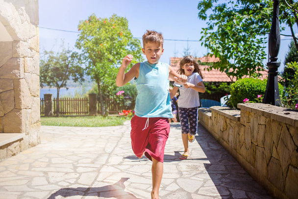 Portrait of two girls, sisters and their boy friend, having fun, running, end of summer. - Foto, afbeelding