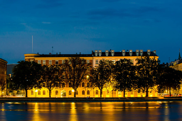 コペンハーゲン、デンマーク、水の上に古い歴史的建造物の夕景。夕暮れ時（青の時間）) - 写真・画像