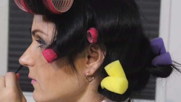 Nainen, jolla on papiljotit hiuksissa lähikuva
 - Materiaali, video