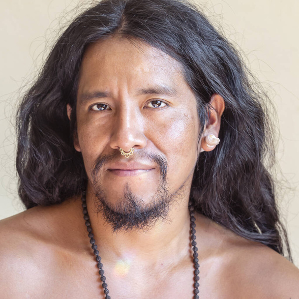Muotokuva nuori latino mies pitkät hiukset yllään metalli väliseinä lävistyksiä nenäänsä
 - Valokuva, kuva