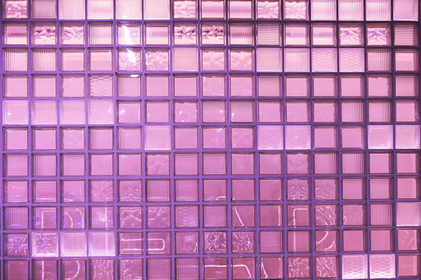Lumière inégale et colorée réfléchit à travers le mur de briques de verre, couleur rose pourpre. vitrine
 - Photo, image