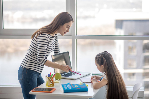 Young mother is engaged in lessons with daughter a schoolgirl. - Φωτογραφία, εικόνα