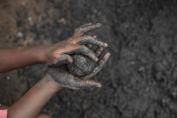 Children's hands making charcoal fuel, Uganda. - Photo, Image