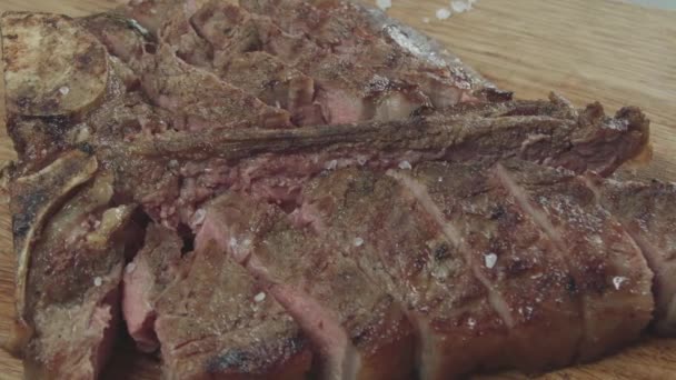 The greens fall on an appetizing medium rare steak - Footage, Video