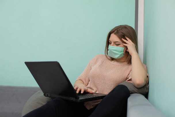 In the academic room you must be in a face mask to reduce the risk of infection. The teenager sits on a bed in a dormitory in a protective mask. - Foto, immagini