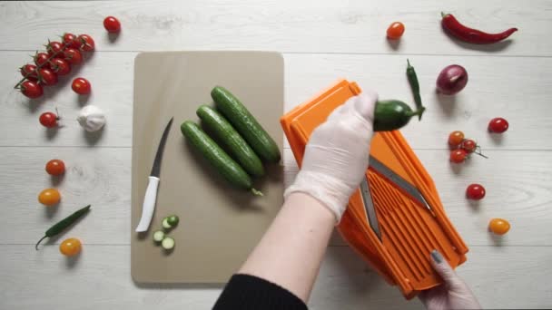 Chef cuts cucumbers on plastic Grater - Footage, Video