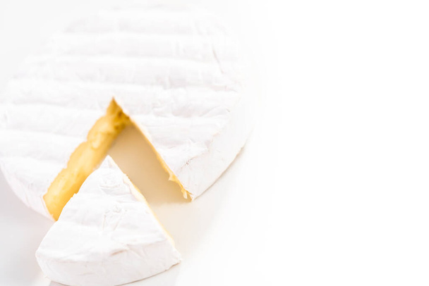 Large slice of brie cheese on a white background. - Foto, imagen