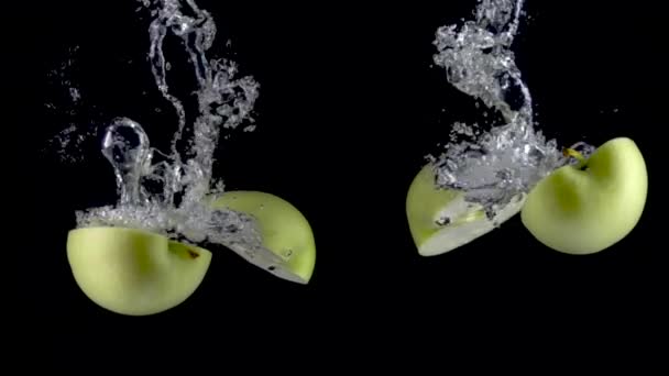 Jabłka wpadają do wody. Zwolniony ruch 500fps - Materiał filmowy, wideo