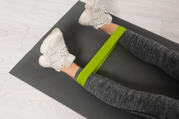 cropped view of woman working out with resistance band on fitness mat - Foto, immagini