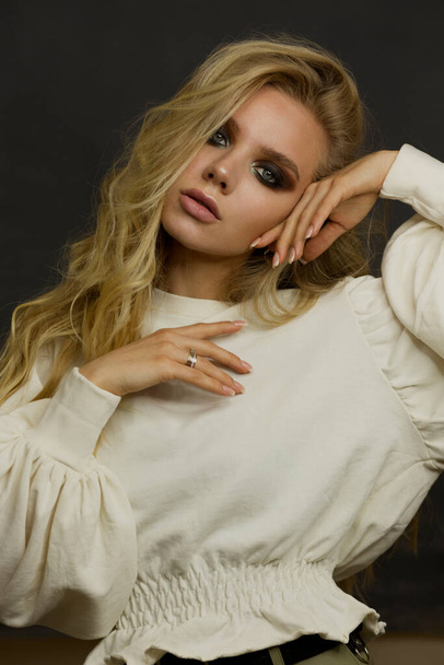 Retrato de una hermosa mujer elegante con ojos humeantes. Posando en el estudio con una blusa blanca. Color monocromo. Belleza y moda
. - Foto, Imagen