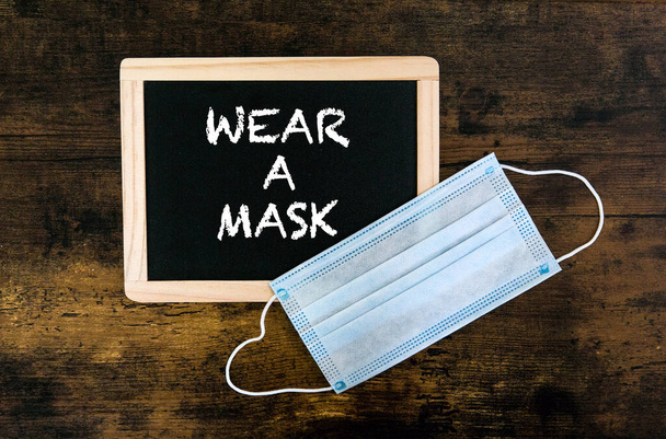 facemask and blackboard with the words Wear A Mask - Foto, immagini