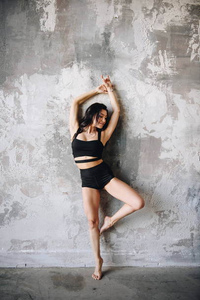 Healthy lifestyle. Proper nutrition. Sports at home. Exercises on the press. Stretching A girl with dark hair, oriental appearance. Tightened figure. Diet, weight loss. Twine. Sportswear. - 写真・画像