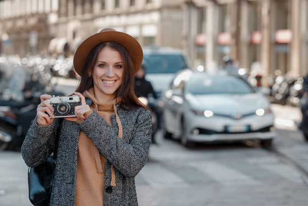 Beautiful brunette tourist girl walking around the city with a camera - Φωτογραφία, εικόνα