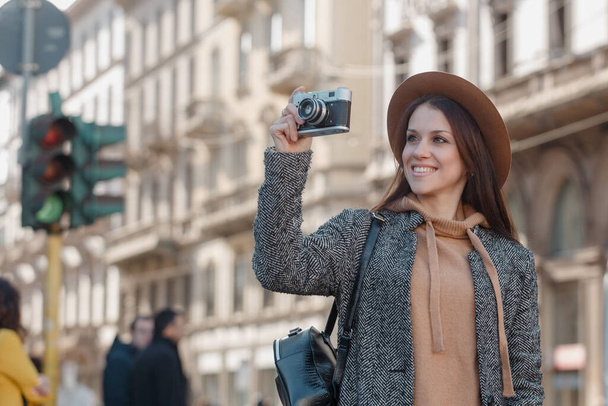Güzel esmer turist kız elinde bir kamera tutuyor ve dinlenme yerinin fotoğraflarını çekiyor.. - Fotoğraf, Görsel