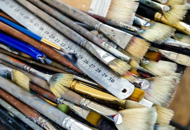 Uma régua de metal e conjunto de diferentes tamanhos escovas do artista para pintura a óleo
 - Foto, Imagem