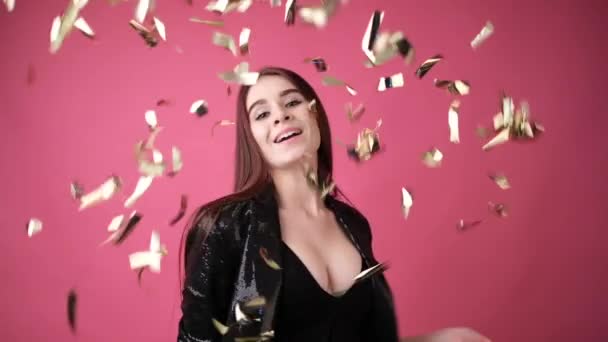 young woman in studio on a pink background with in crumbling confetti - Video, Çekim