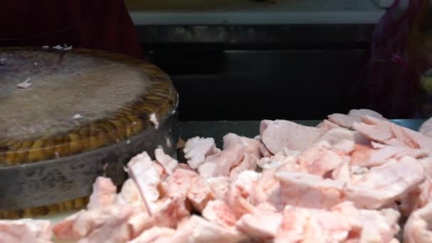 Slow motion of asian hands of pork shop owner is using knife to cut slices of raw meat on a wooden cutting board at local food street traditional market of Taipei. Famous marketplace Taiwan-Dan - Felvétel, videó
