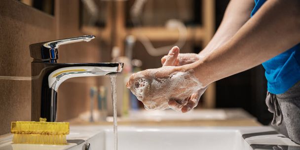 Vista de cerca de la mujer lavándose las manos a fondo con jabón desinfectante espumoso en el baño en casa
. - Foto, imagen