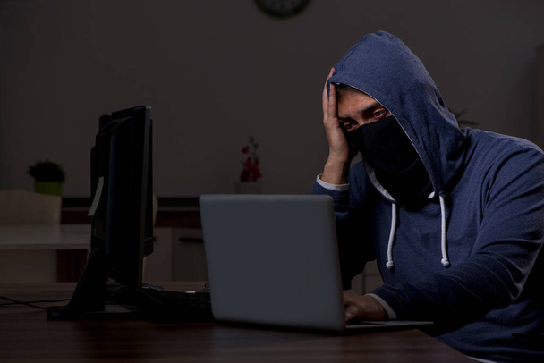 Hombre hacker piratería firewall de seguridad tarde en la oficina - Foto, imagen