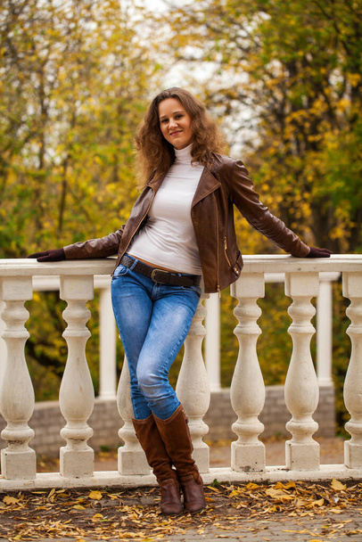 Portrait of a young beautiful brunette woman in autumn park - Foto, Imagem