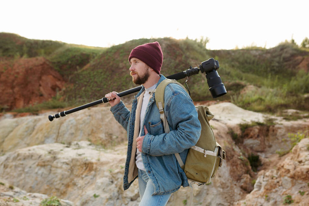 Bearded male videographer preparing for video shooting at a clay quarry - Foto, afbeelding