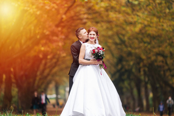 Sunshine portrait of happy bride and groom outdoor in nature location at sunset. Warm summertime. - Foto, Imagen