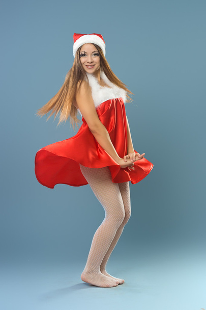 girl in red dress and santa claus hat - Foto, imagen