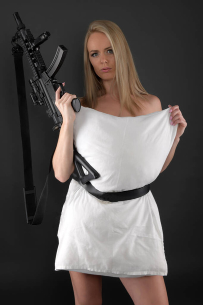 Sexy blonde woman holding gun - Фото, изображение
